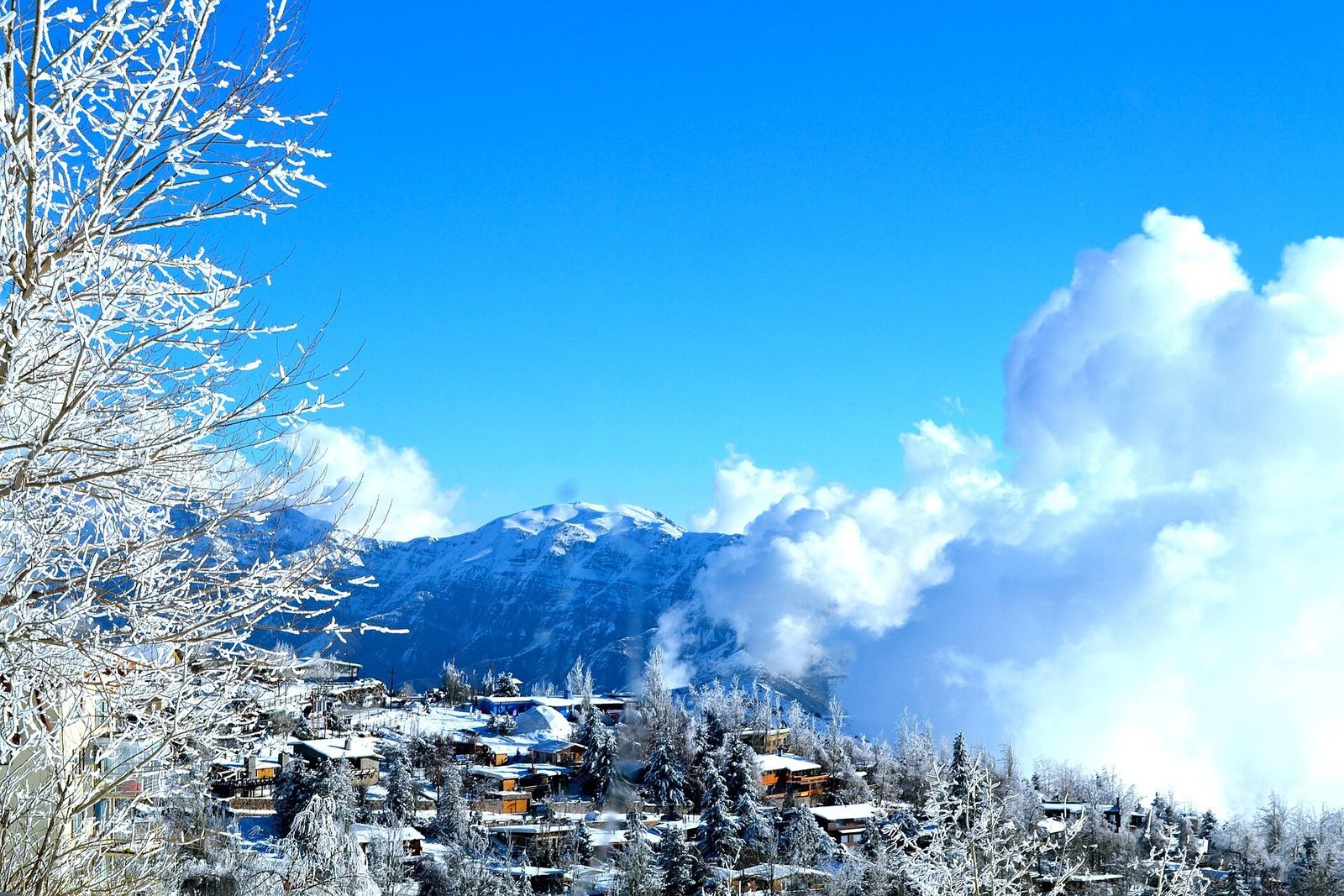 A vila de Farellones coberta de neve, com a cordilheira ao fundo