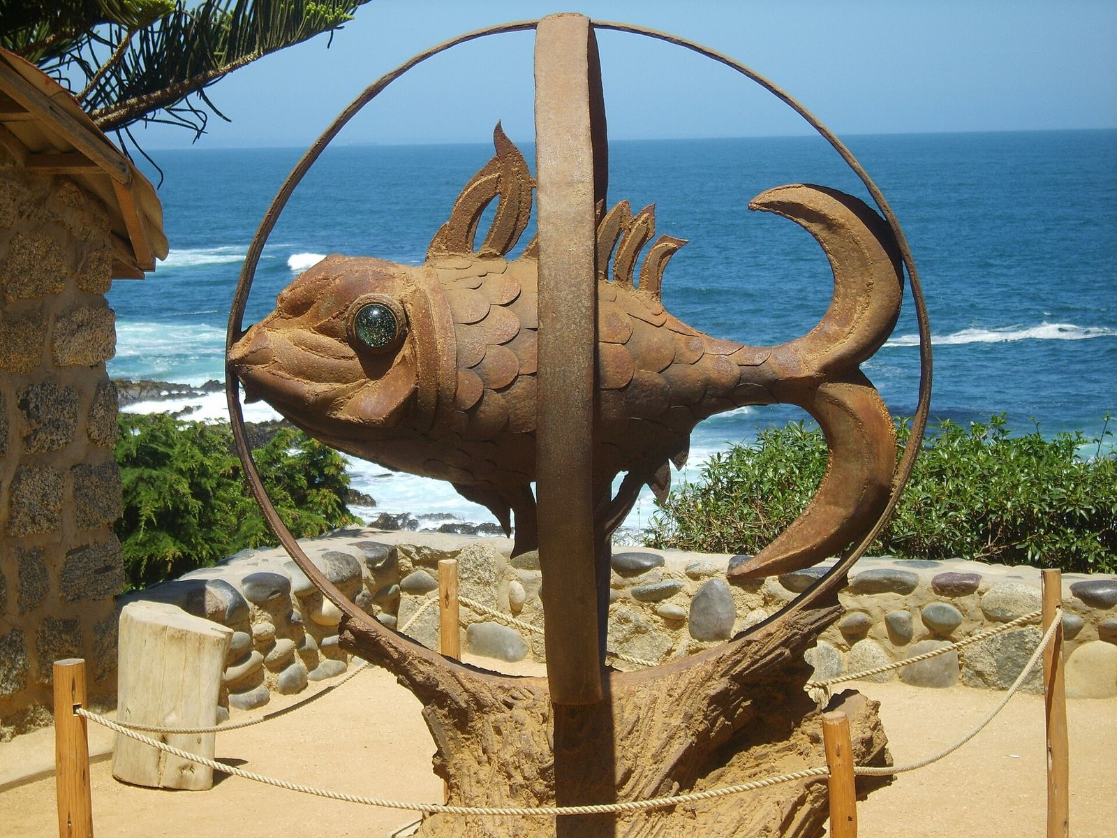 Escultura de peixe no jardim da casa de Pablo Neruda, com o mar ao fundo